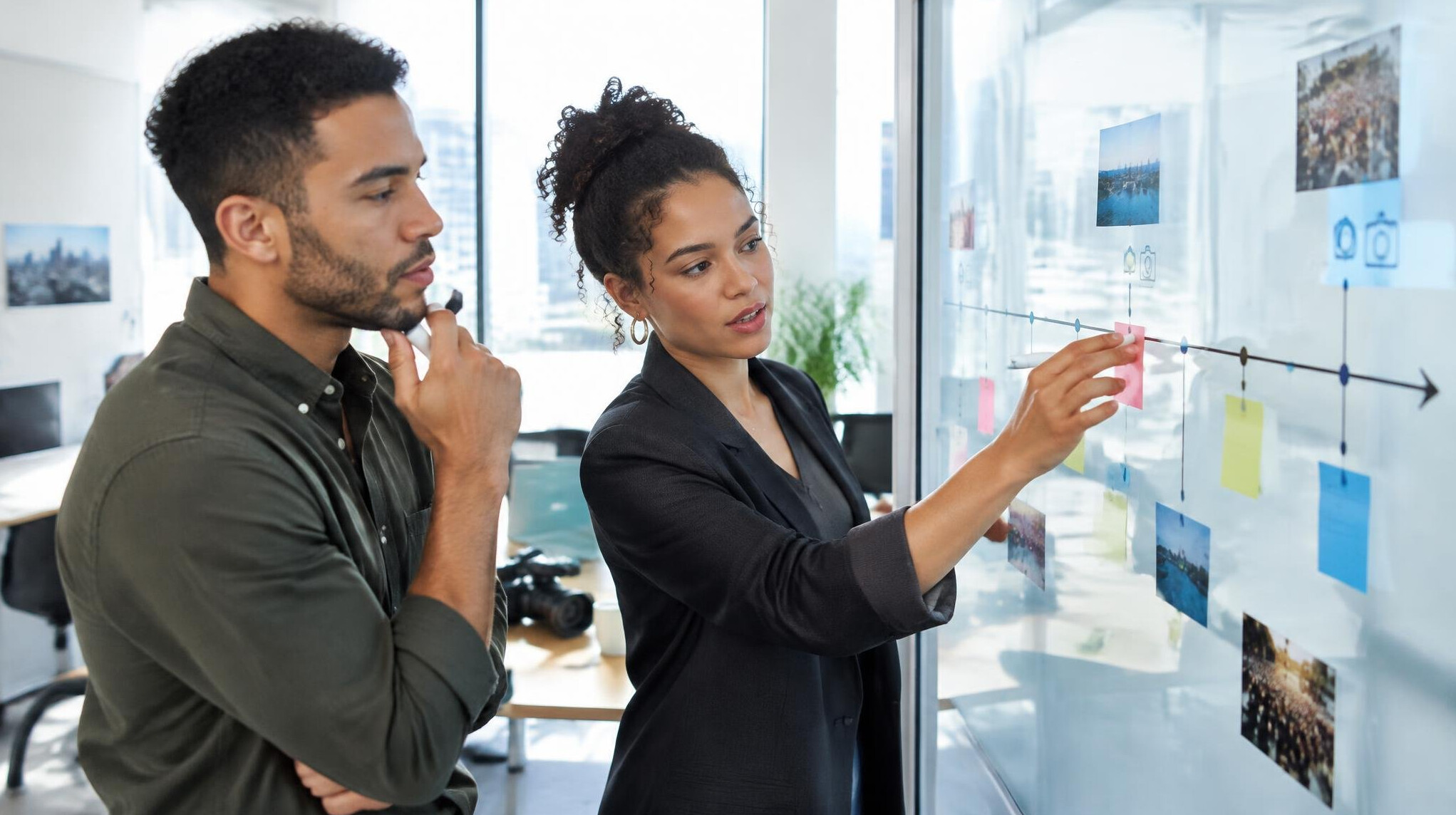 Journalists mapping out a story timeline on a glass whiteboard